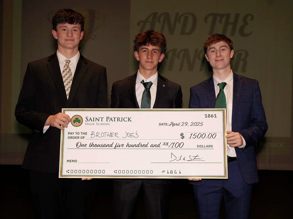 Rocco and two classmates holding a $1,500 Saint Patrick High School check made out to Brother Joe's